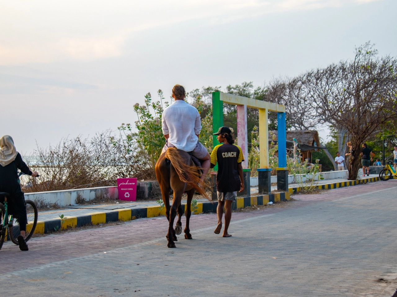 person riding a horse on gili trawangan during sunset